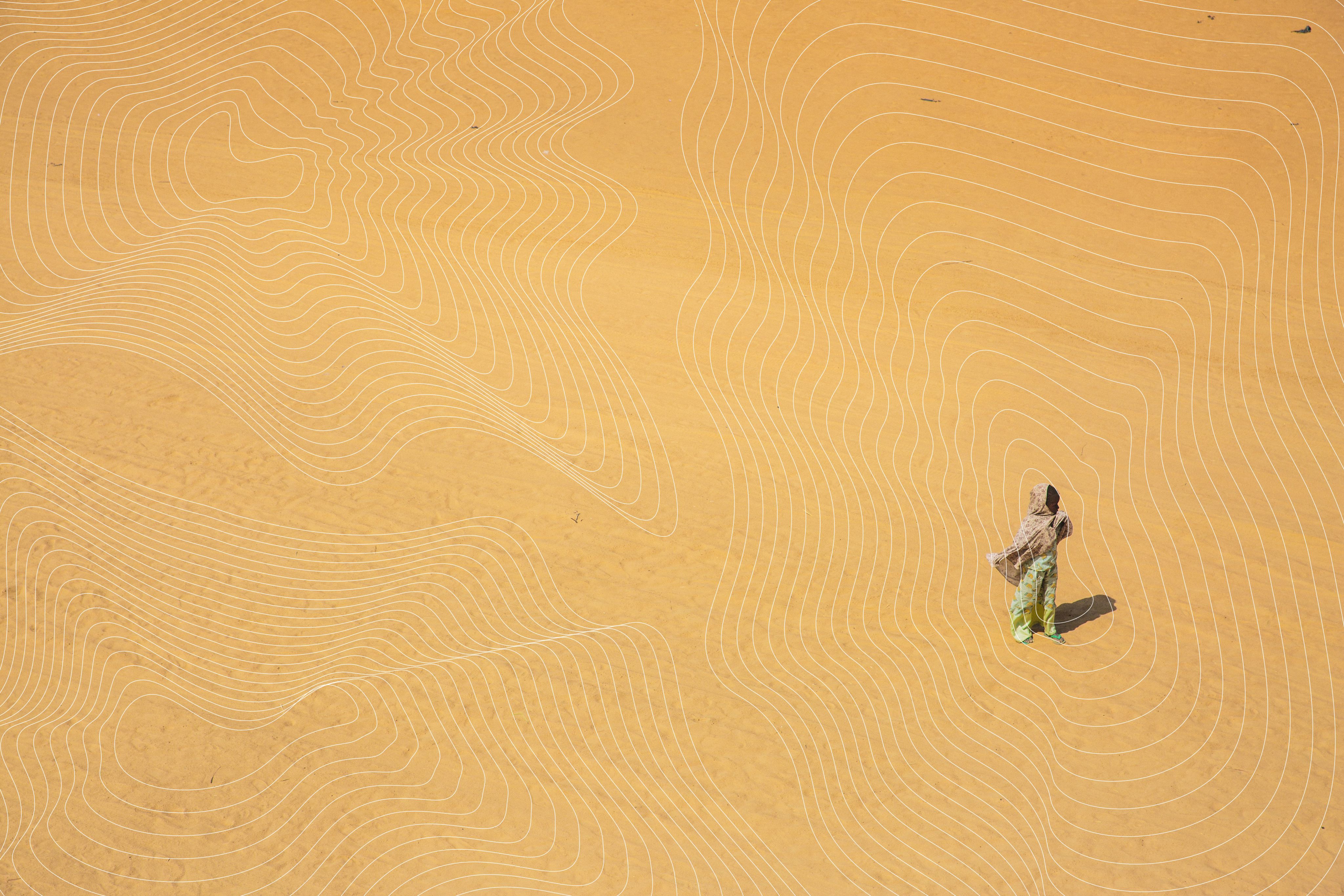 Lone human figure standing in vast golden sands near the Bakasi IDP camp in Nigeria