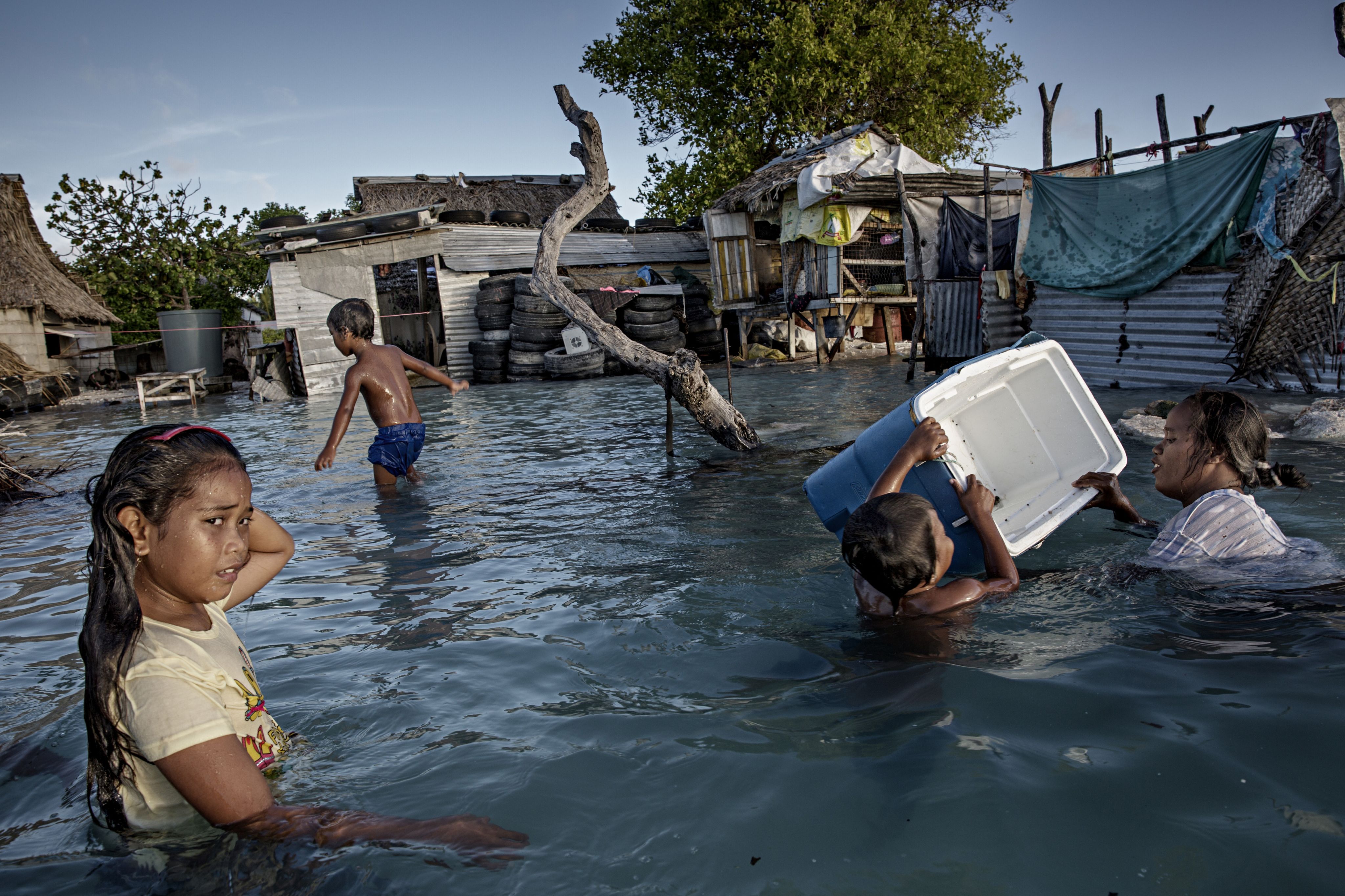 Children playing in the water in the village of Eita in the nation of Kiribati, which is only two metres above sea level and already feeling the impact of rising sea levels.